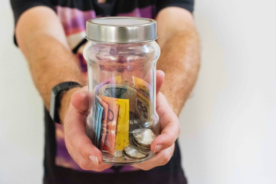 Person holding glass jar emergency savings