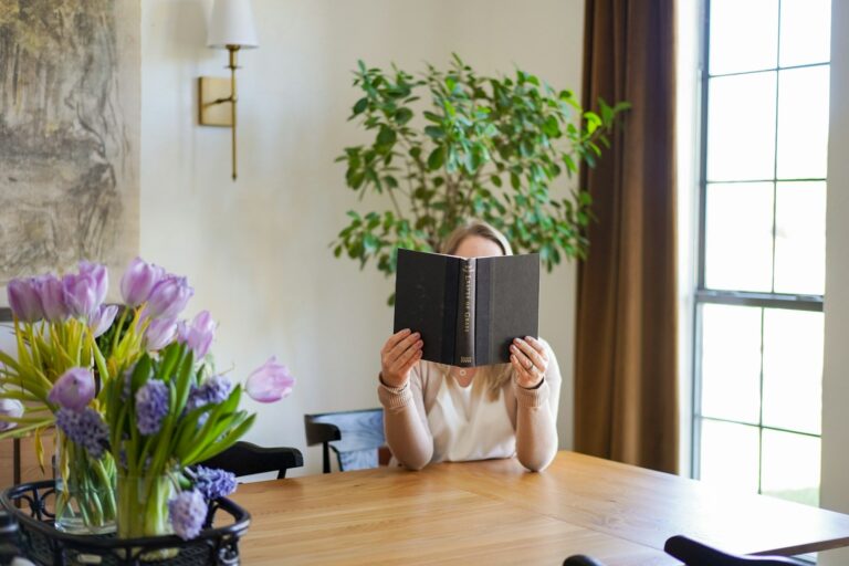 Woman reading book sofa natural light