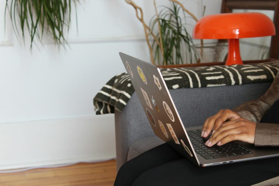 Person online shopping laptop credit card living room