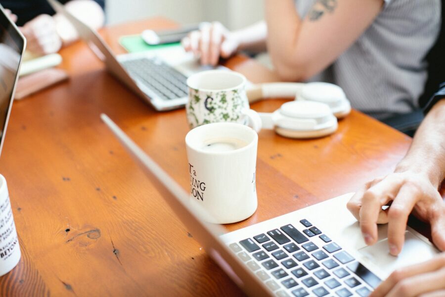 Person reviewing bank statements laptop coffee table