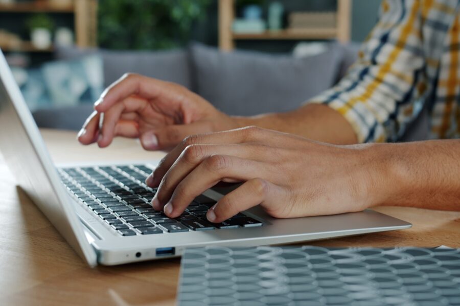 Person using laptop chatbot interface home desk