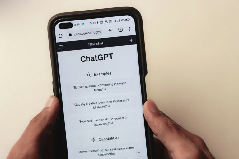Chatbot conversation smartphone screen person planning notebook laptop