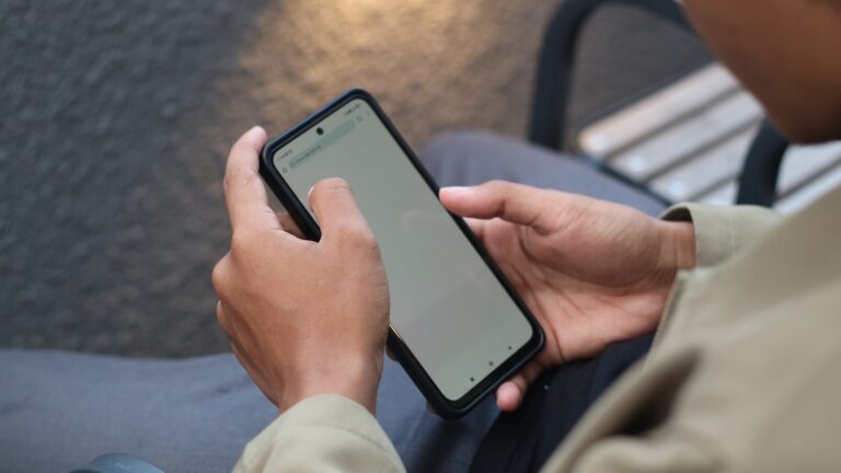 Person holding phone reviewing app permissions
