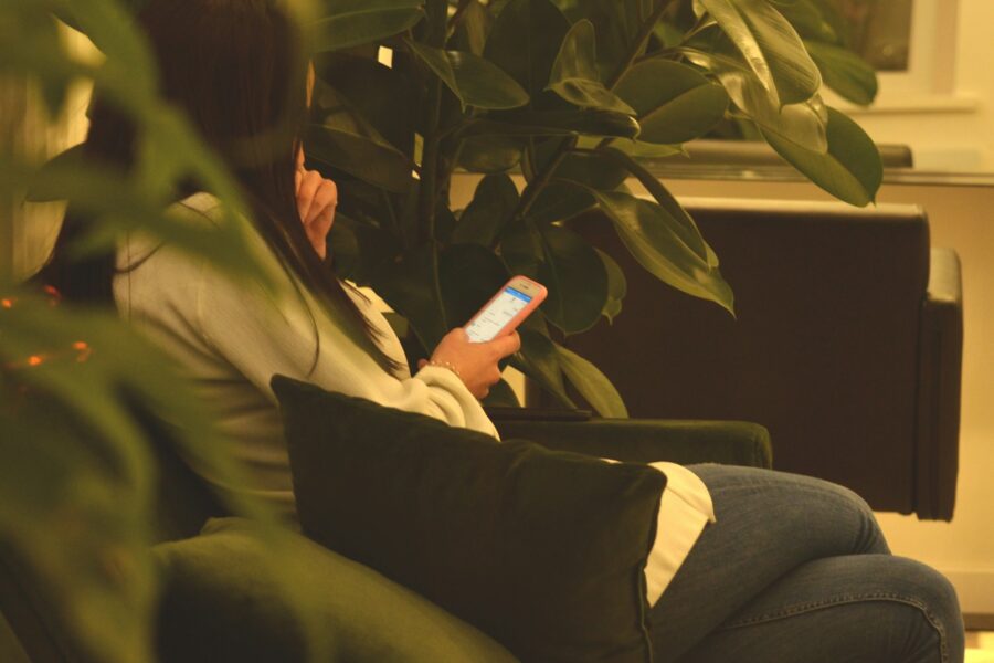 Person relaxing sofa phone soft light