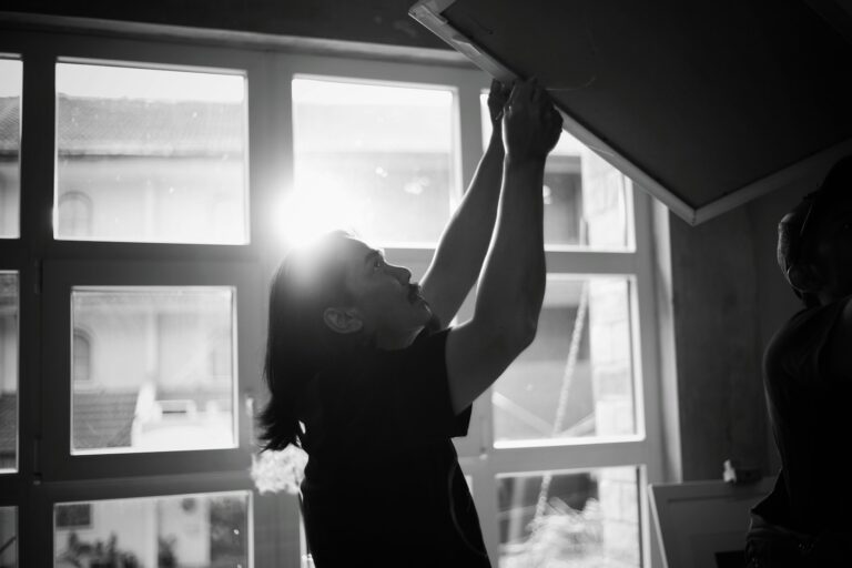 Person stretching window morning light