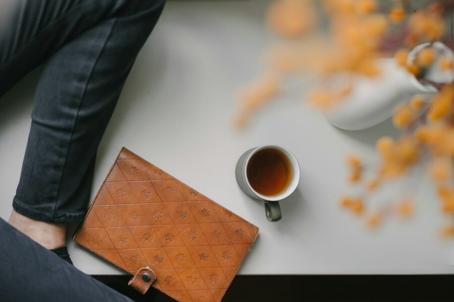 Person sitting desk taking short break notebook coffee
